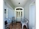 Inviting front porch with tiled floor, seating and an ornate front door, surrounded by decorative plants and flowers at 827 Princeton Dr, Clermont, FL 34711