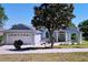 Charming single-story home with beautifully landscaped front yard, a well-maintained lawn and flowering trees at 827 Princeton Dr, Clermont, FL 34711