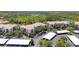 Aerial view of condo buildings showcasing parking, landscaping and nearby trees and pond at 8296 Portofino Dr # 405, Davenport, FL 33896