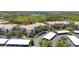 Aerial view of condo buildings showcasing parking, landscaping and nearby trees and pond at 8296 Portofino Dr # 405, Davenport, FL 33896