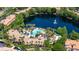Aerial shot of community pool and clubhouse surrounded by lush landscaping and a serene lake at 8296 Portofino Dr # 405, Davenport, FL 33896