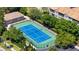 Aerial view of the community tennis court surrounded by trees and well maintained landscaping at 8296 Portofino Dr # 405, Davenport, FL 33896