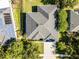 Aerial shot of a well-maintained roof, concrete driveway, lush lawn, and mature tree providing shade and curb appeal at 849 Shadowmoss Dr, Winter Garden, FL 34787