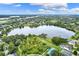 Aerial view of a lake community showcasing homes, trees, and a tranquil lake at 849 Shadowmoss Dr, Winter Garden, FL 34787