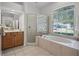 Bright bathroom featuring a large soaking tub and a glass-enclosed shower with a window view at 849 Shadowmoss Dr, Winter Garden, FL 34787