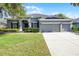 Charming single-Gathering home showcasing a well-manicured lawn, grey trim, and a convenient three-car garage at 849 Shadowmoss Dr, Winter Garden, FL 34787