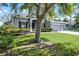 Beautifully landscaped home exterior displaying a lush green lawn, mature trees, and a three-car garage at 849 Shadowmoss Dr, Winter Garden, FL 34787