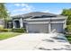 Inviting home featuring a manicured lawn and a spacious driveway leading to a three-car garage at 849 Shadowmoss Dr, Winter Garden, FL 34787