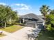 Aerial view of a well-maintained grey house with a three-car garage, lush landscaping, and a palm tree at 849 Shadowmoss Dr, Winter Garden, FL 34787