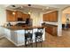 Spacious kitchen features wood cabinetry, granite counters, stainless steel appliances, and bar stool seating at 849 Shadowmoss Dr, Winter Garden, FL 34787