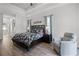 Comfortable main bedroom features tray ceiling, hardwood floors, relaxing armchair, and soft natural light at 849 Shadowmoss Dr, Winter Garden, FL 34787