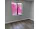 Cozy bedroom with wood-look floors and a sunny window view at 855 Marion Dr, Mount Dora, FL 32757