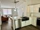 Open kitchen with stainless steel appliances and white cabinets, blending seamlessly into the living area at 855 Marion Dr, Mount Dora, FL 32757