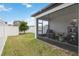 A serene backyard featuring a screen enclosed lanai and a well-maintained lawn with white vinyl fencing for privacy at 8573 Lamppost Ln, Orlando, FL 32832