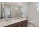 Bathroom features a double sink vanity, large mirror, and a view of the doorway to the hall at 8573 Lamppost Ln, Orlando, FL 32832