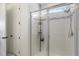 Modern shower with glass enclosure, a tiled interior, and convenient shelving at 8573 Lamppost Ln, Orlando, FL 32832