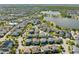 This aerial shot showcases a vibrant community with lush landscaping, a lake, and well-maintained homes at 8665 Theiler St, Orlando, FL 32827