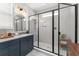 Beautiful bathroom features a single sink vanity, marble countertops, and glass-enclosed shower at 8665 Theiler St, Orlando, FL 32827