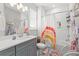 Charming bathroom with tub and shower, and modern vanity with grey cabinets at 8665 Theiler St, Orlando, FL 32827