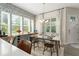 Bright dining area with marble table, built-in cabinets, large windows, designer wallpaper and modern chandelier at 8665 Theiler St, Orlando, FL 32827