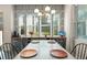 The dining room features large windows, wallpaper, a chandelier, and a table with four place settings at 8665 Theiler St, Orlando, FL 32827