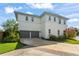 Two-story home featuring a large two car garage and well-maintained landscaping at 8665 Theiler St, Orlando, FL 32827