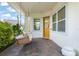 Inviting front porch featuring a porch swing, decorative wreath, and brick flooring at 8665 Theiler St, Orlando, FL 32827