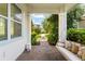 View from covered porch featuring a swing, showcasing the brick flooring and serene neighborhood at 8665 Theiler St, Orlando, FL 32827
