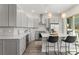 Bright, modern kitchen with stainless steel appliances, grey cabinets, pendant lighting, and an island with bar seating at 8665 Theiler St, Orlando, FL 32827
