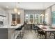 Open-concept kitchen with an island, pendant lighting, stainless appliances, and a view into the dining area and backyard at 8665 Theiler St, Orlando, FL 32827