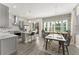Open-concept kitchen featuring gray cabinets, pendant lighting, and an island with bar seating that flows into the dining area at 8665 Theiler St, Orlando, FL 32827