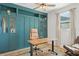 Office featuring a teal built-in cabinet, desk, rolling chair, and a ceiling fan at 8665 Theiler St, Orlando, FL 32827