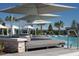 Upscale pool features luxury lounge seating with sun shades, palm trees, and access to the beautiful blue water at 8665 Theiler St, Orlando, FL 32827