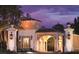 Elegant community entrance at twilight, showcasing detailed architecture and warm lighting at 10160 Autumn Mist Ln # 601, Golden Oak, FL 32836