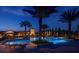 Community pool illuminated at night, bordered by palm trees and resort-style amenities at 10160 Autumn Mist Ln # 601, Golden Oak, FL 32836