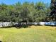Large grassy backyard featuring mature trees and a white fence at 1053 Tourmaline Dr, Kissimmee, FL 34746