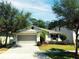 Charming single-story home with a well-manicured lawn, mature trees, and a two-car garage at 1053 Tourmaline Dr, Kissimmee, FL 34746