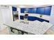 Updated kitchen featuring blue cabinets, granite counters, a pantry, and an island with sink at 1053 Tourmaline Dr, Kissimmee, FL 34746