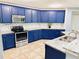 Modern kitchen with stylish blue cabinets, granite countertops, and stainless steel appliances at 1053 Tourmaline Dr, Kissimmee, FL 34746