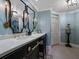 Bathroom showcasing a long vanity with double mirrors, and sconce lighting, and blue wall at 1110 W Ivanhoe Blvd # 15, Orlando, FL 32804