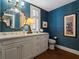 Bathroom featuring blue walls, a large mirror and white vanity with a grey cabinet at 1110 W Ivanhoe Blvd # 15, Orlando, FL 32804