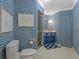 Full bathroom with blue patterned wallpaper, a stall shower, and white tile flooring at 1110 W Ivanhoe Blvd # 15, Orlando, FL 32804