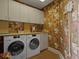 This laundry room features Miele washer/dryer, ample cabinet space, countertop, and unique wallpaper at 1110 W Ivanhoe Blvd # 15, Orlando, FL 32804