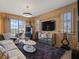 Living room with wood-paneled walls, neutral sofa, and a view from the balcony at 1110 W Ivanhoe Blvd # 15, Orlando, FL 32804