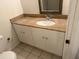 Bathroom vanity with granite countertop, white cabinetry, a framed mirror, and a white sink at 11574 Westwood Blvd # 1126, Orlando, FL 32821