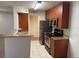 Well-lit kitchen with stainless steel appliances, wood cabinets, and breakfast bar at 11574 Westwood Blvd # 1126, Orlando, FL 32821