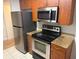 Stainless steel appliances with wooden cabinetry and granite countertops create a modern kitchen space at 11574 Westwood Blvd # 1126, Orlando, FL 32821