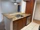 Open-concept kitchen with sink, granite countertop, wooden cabinets, and stainless steel dishwasher at 11574 Westwood Blvd # 1126, Orlando, FL 32821