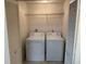 A stacked washer and dryer in a laundry closet with white appliances and wire shelving above at 11574 Westwood Blvd # 1126, Orlando, FL 32821