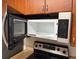 A stainless steel microwave above a range with wood cabinets adding a touch of warmth to the kitchen at 11574 Westwood Blvd # 1126, Orlando, FL 32821